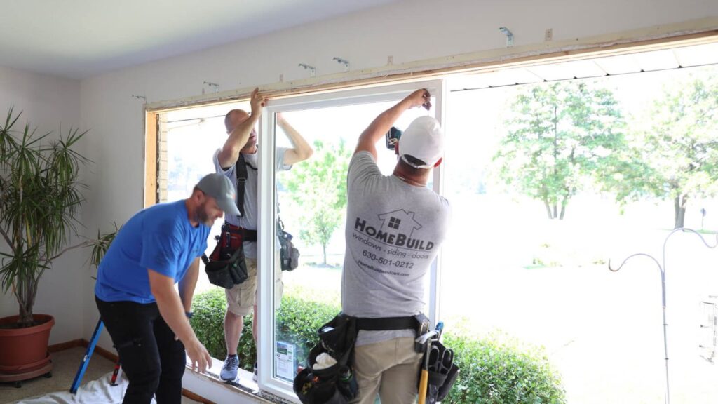 Workers installing a new window in a home.