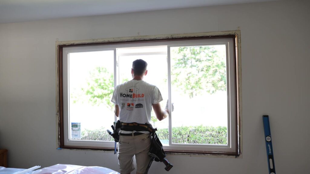 A person installing a new window in a room.