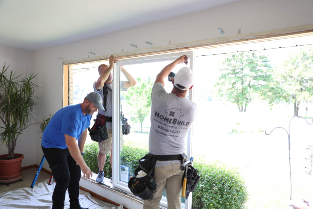 Workers installing a new window in a home.