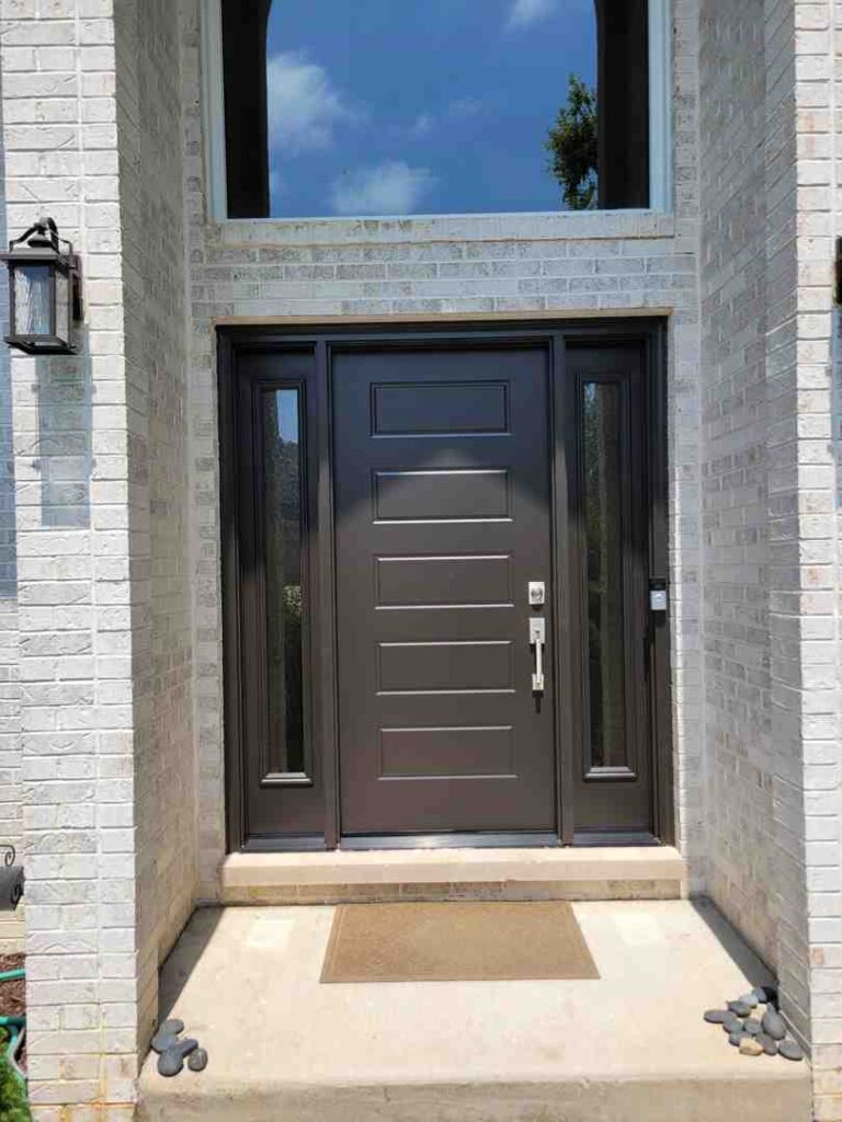 Craftsman style 3/4 lite fiberglass entry door with dual sidelights on residential home